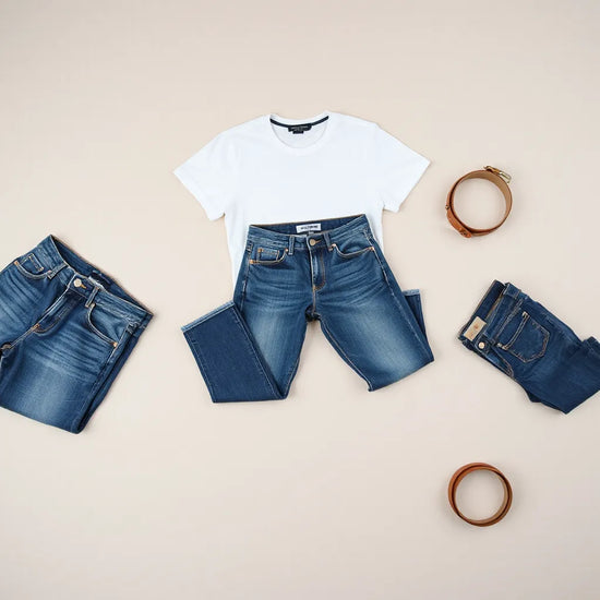 Mehrere Herrenjeans in verschiedenen Passformen auf neutralem Untergrund, mit sichtbaren Nähten und Stofftextur