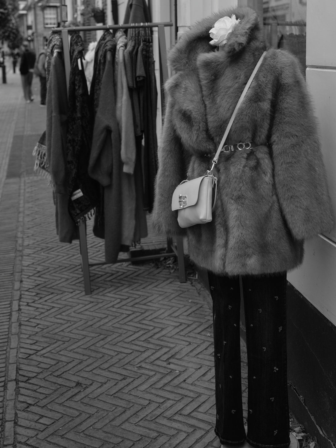 Mannequin wearing fur coat and purse outside shop
