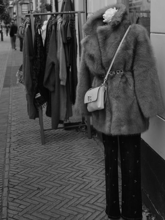 Mannequin wearing fur coat and purse outside shop
