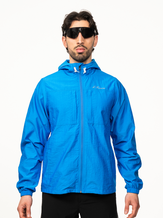 Blauer Windbreaker von Next Level, Vorderansicht, leichte Jacke mit Reißverschluss und sportlichem Design.