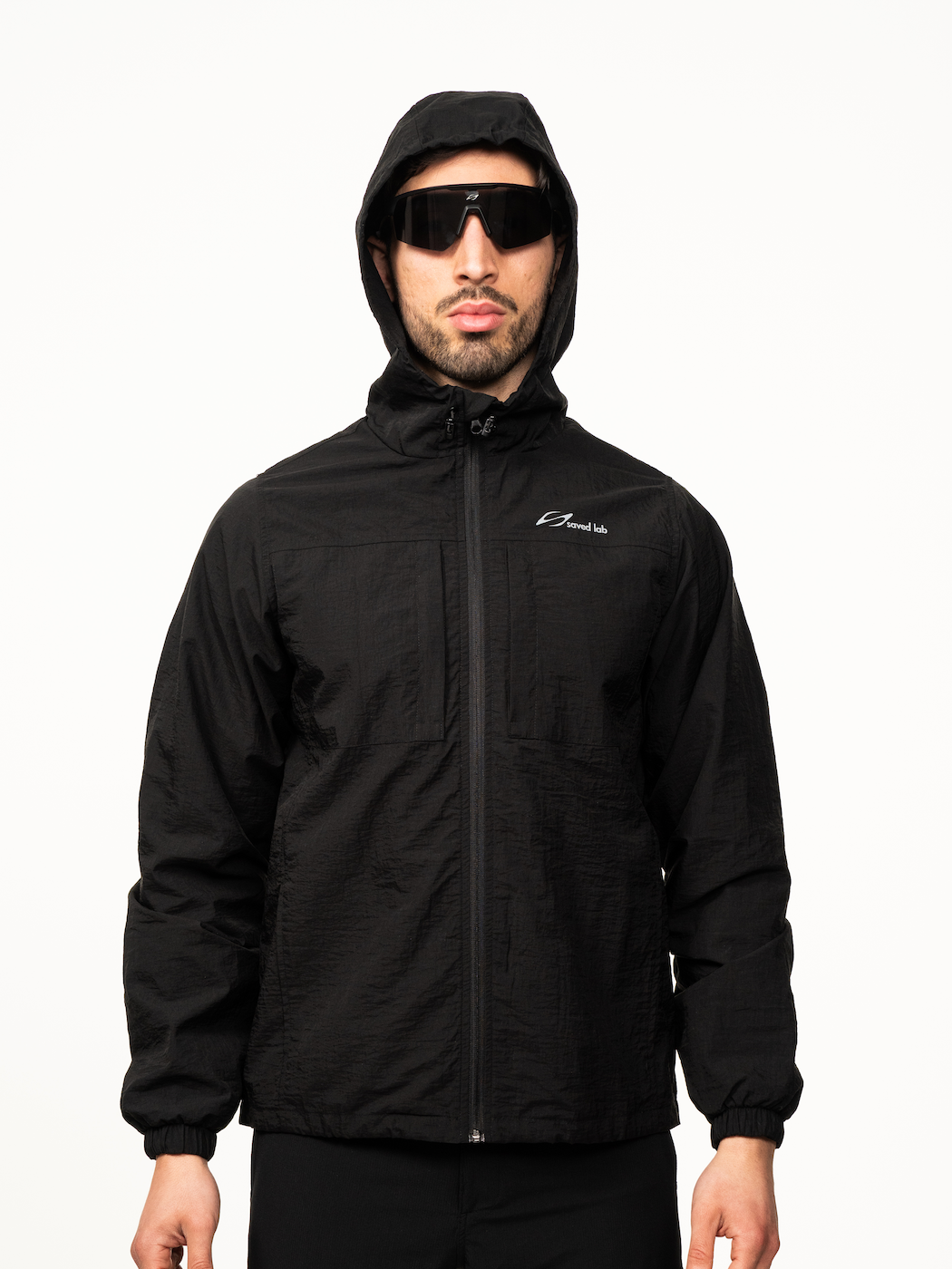 Schwarzer Windbreaker von Next Level, leichtes wetterfestes Jacken-Design mit Kapuze und Reißverschluss.