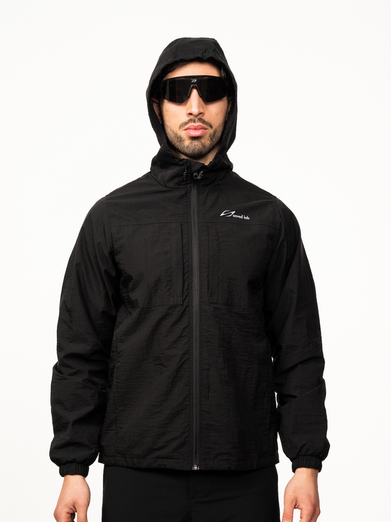 Schwarzer Windbreaker von Next Level, leichtes wetterfestes Jacken-Design mit Kapuze und Reißverschluss.